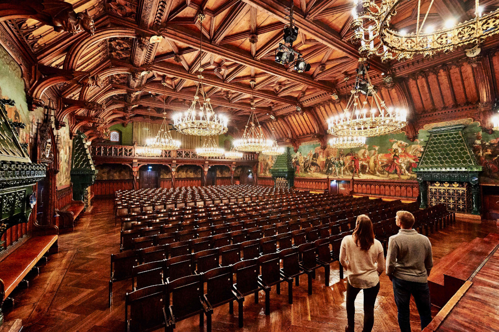           Im Prunksaal des Landshuter Rathauses fasziniert ein eindrucksvolles Umlaufgemälde, das den Festzug mit Brautwagen während der Landshuter Hochzeit zeigt. Foto: Tourismusverband Ostbayern                          