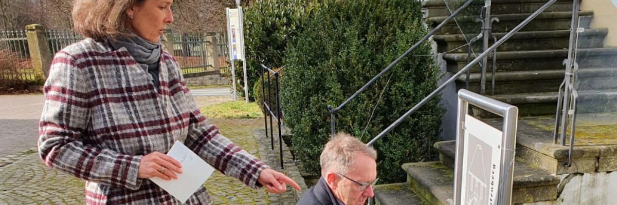 Gräfin von Westphalen und Antonius Monkos, Geschäftsführer der Historischen Fürstenberg gGmbH, bringen den QR-Code zum Sprechenden Denkmal an ©WestLotto) 